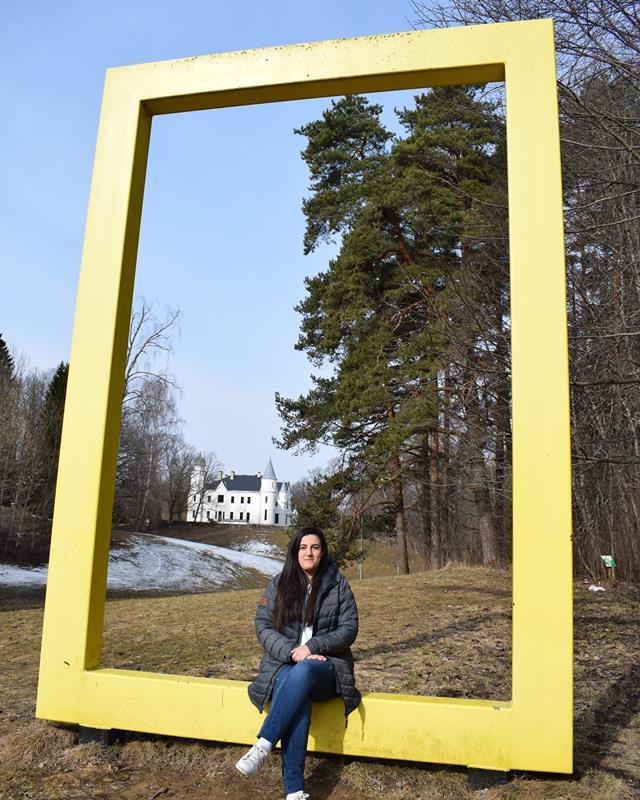 Im Park des Schlosses Alatskivi befindet sich das gelbe Fenster von National Geographic, dort sitzt eine junge Frau.