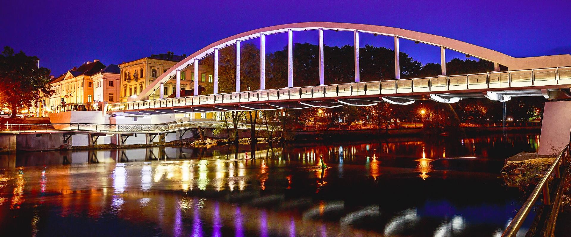Arku tilts vasaras vakara gaismās atspoguļo apgaismojumu Emajegi upē