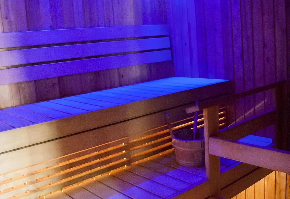Pööni kõrts-külalistemaja sauna leiliruum, sinise valgustusega, puidust lava