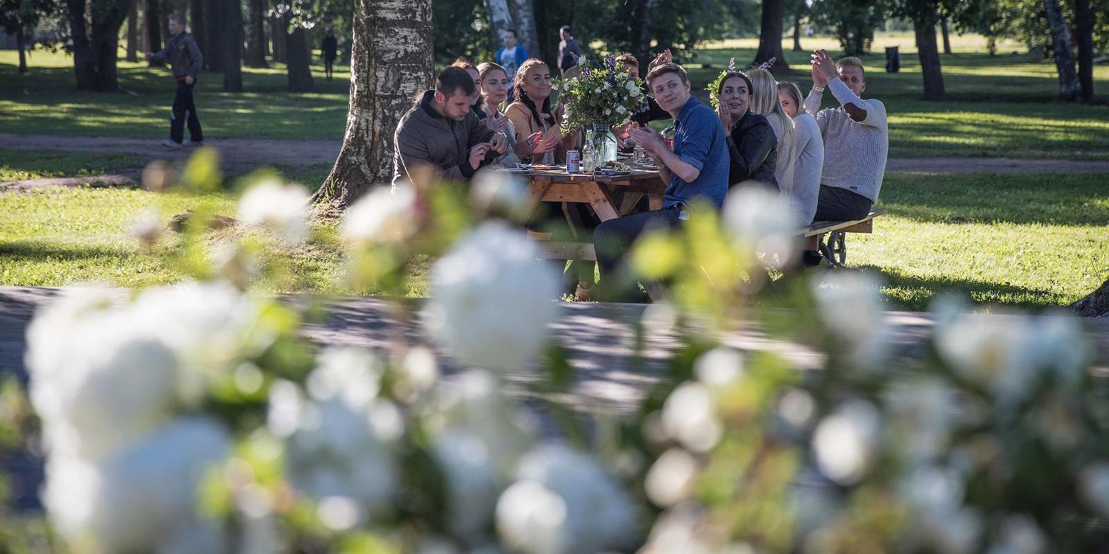 "Ranna Puhkebaas" vasaras zaļumā / cilvēki ietur maltīti