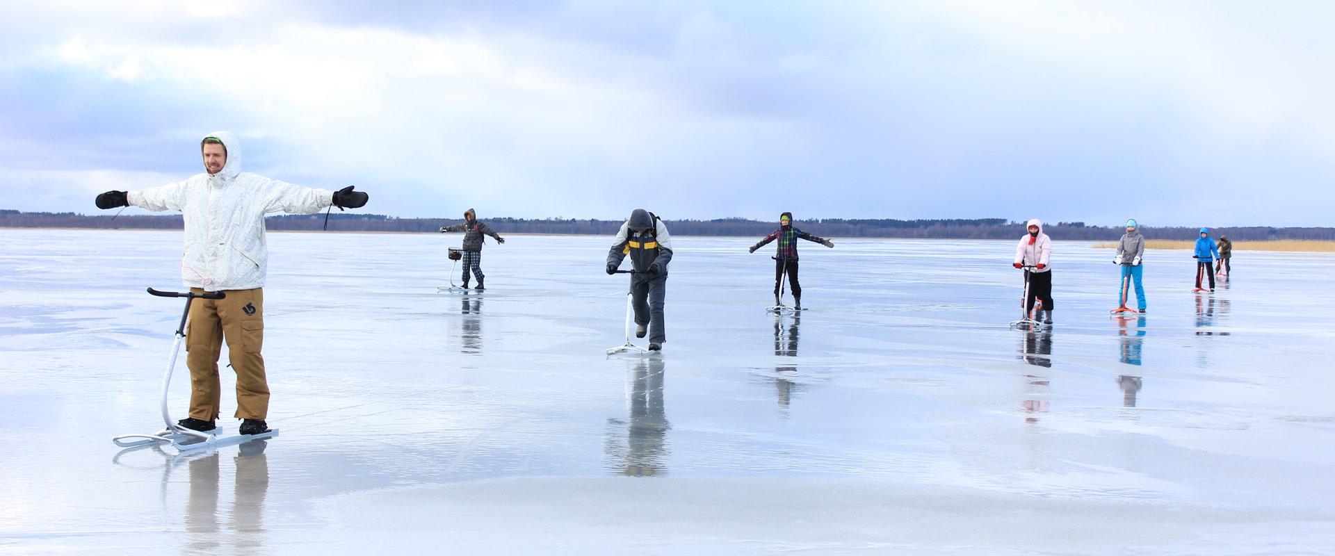 Menschen mit Tretschlitten auf dem Eis des Sees Võrtsjärv