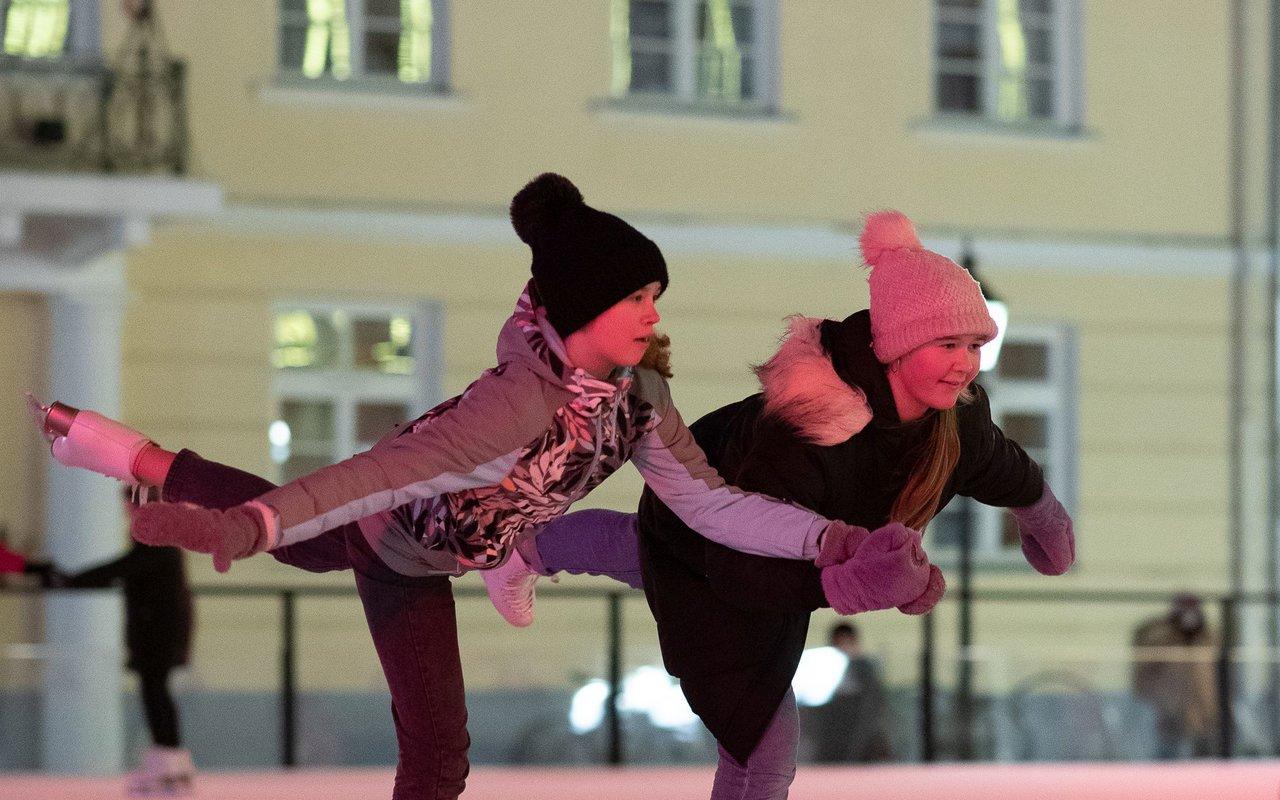 Happy skaters doing ice tricks on the ice rink in the heart of Tartu