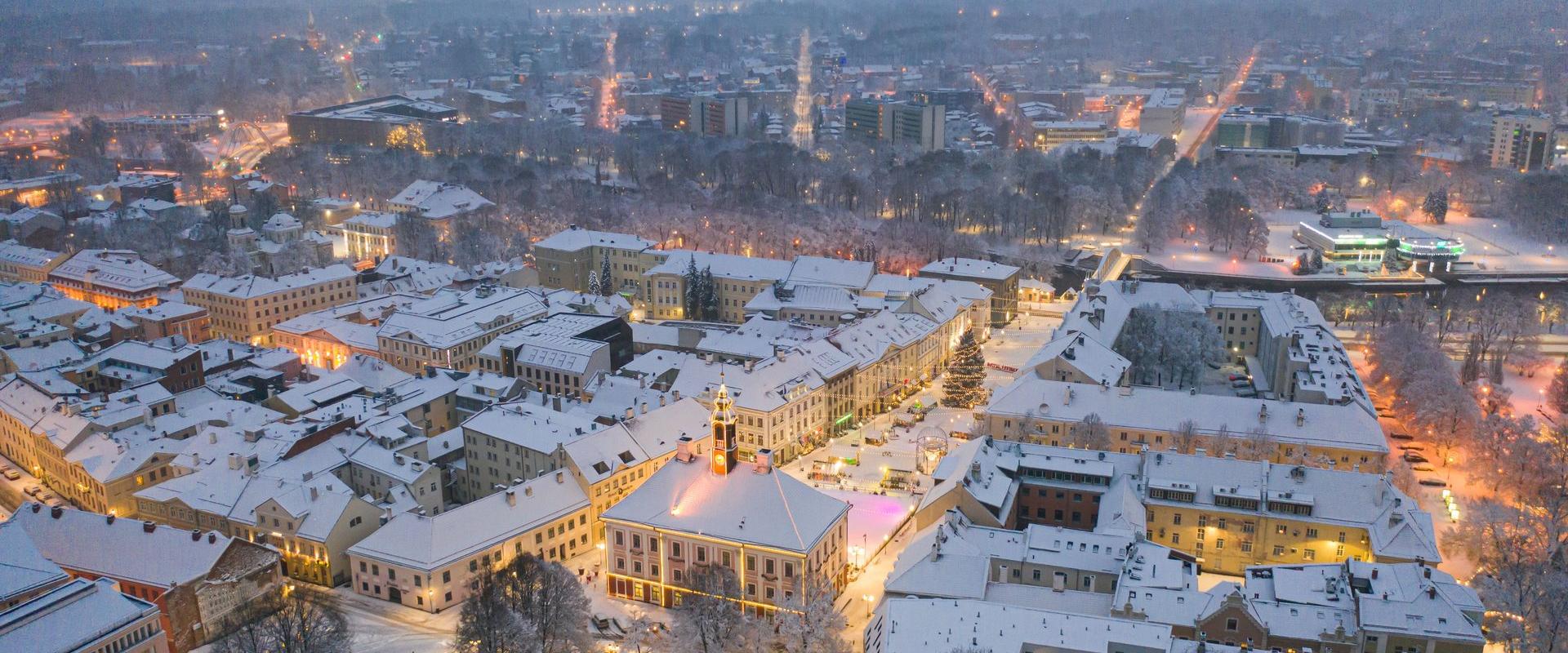 Blick auf die Bogenbrücke und die schneebedeckten Dächer im abendlichen Tartu