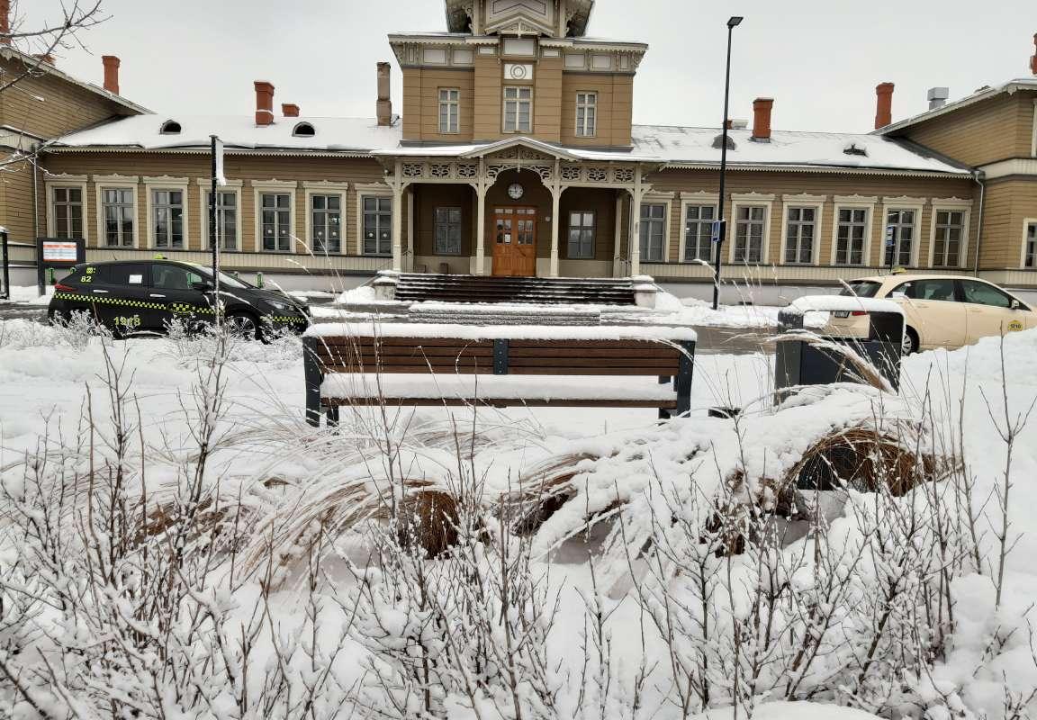 Tartu raudteejaam lumisel talvel ning selle ees asuv buss- ja taksopeatus