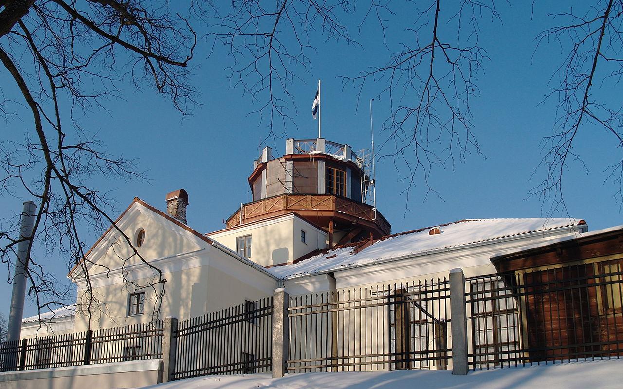 Tartu observatorija sniegotā ziemā, tornī plīvo zili-melni-baltais karogs