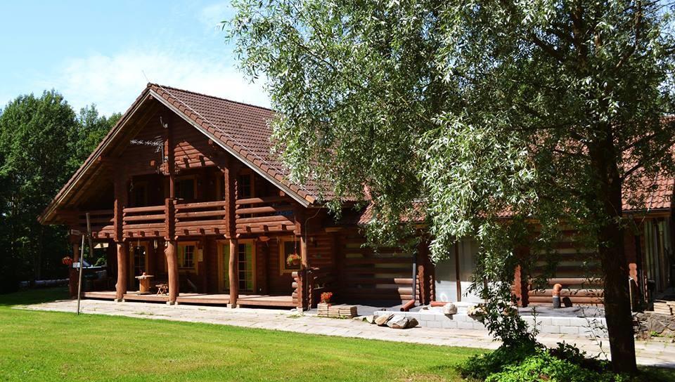 Palkidest ehitatud Lasita Puhkemaja peahoone Tartumaal, suvises roheluses Kavilda ürgorus