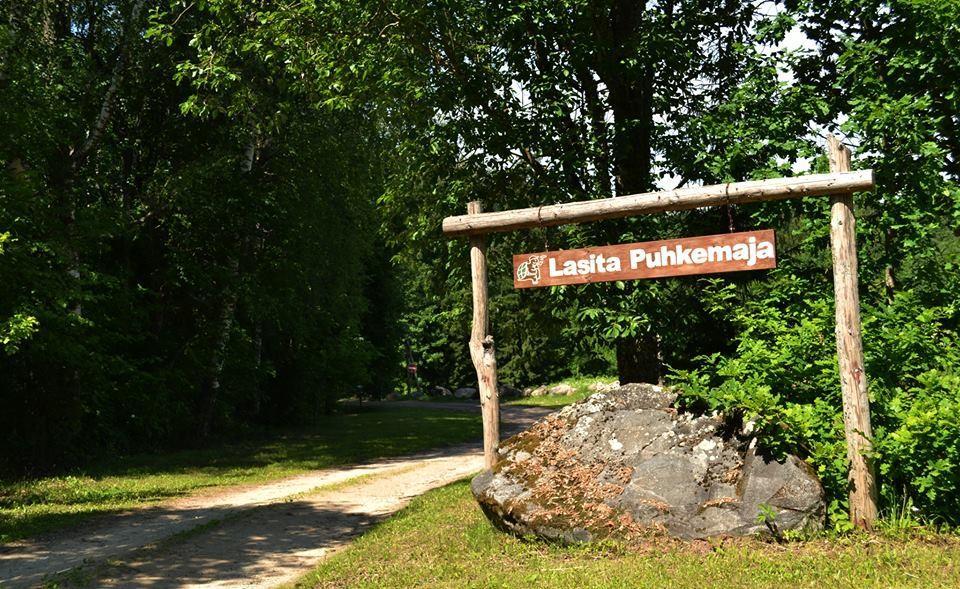 Puidust silt Lasita Puhkemaja nimega Kavilda ürgorus Tartumaal, ümbritsetud roheluse ja metsateega