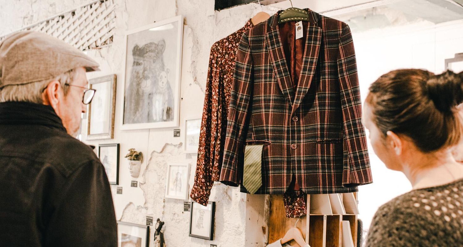 Besucher sehen sich Vintage-Kleidung und Drucke an