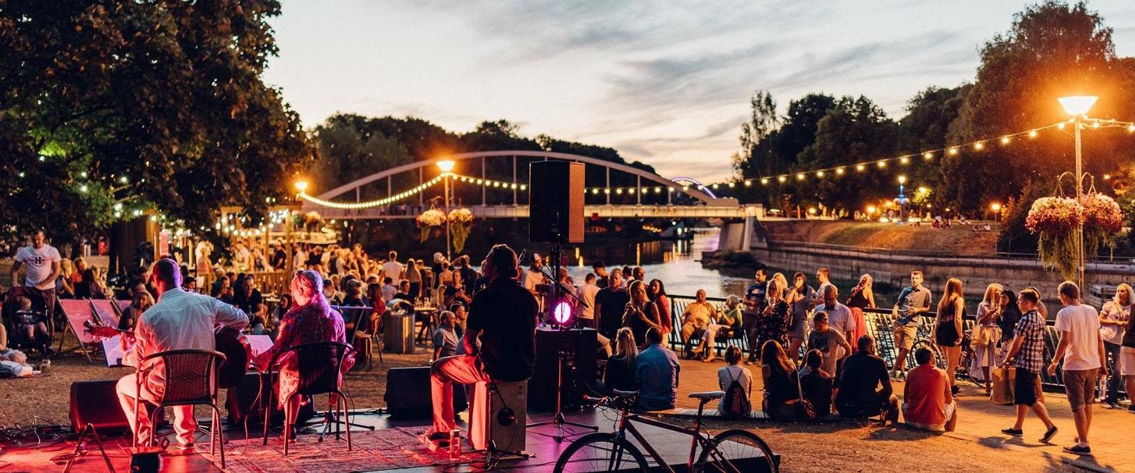 Virtual tour of the city of Tartu: people having fun by the Emajõgi River in summer