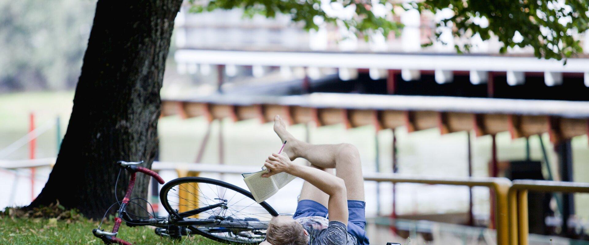 Emajõe Riviera promenade and a man with a bike reading a book