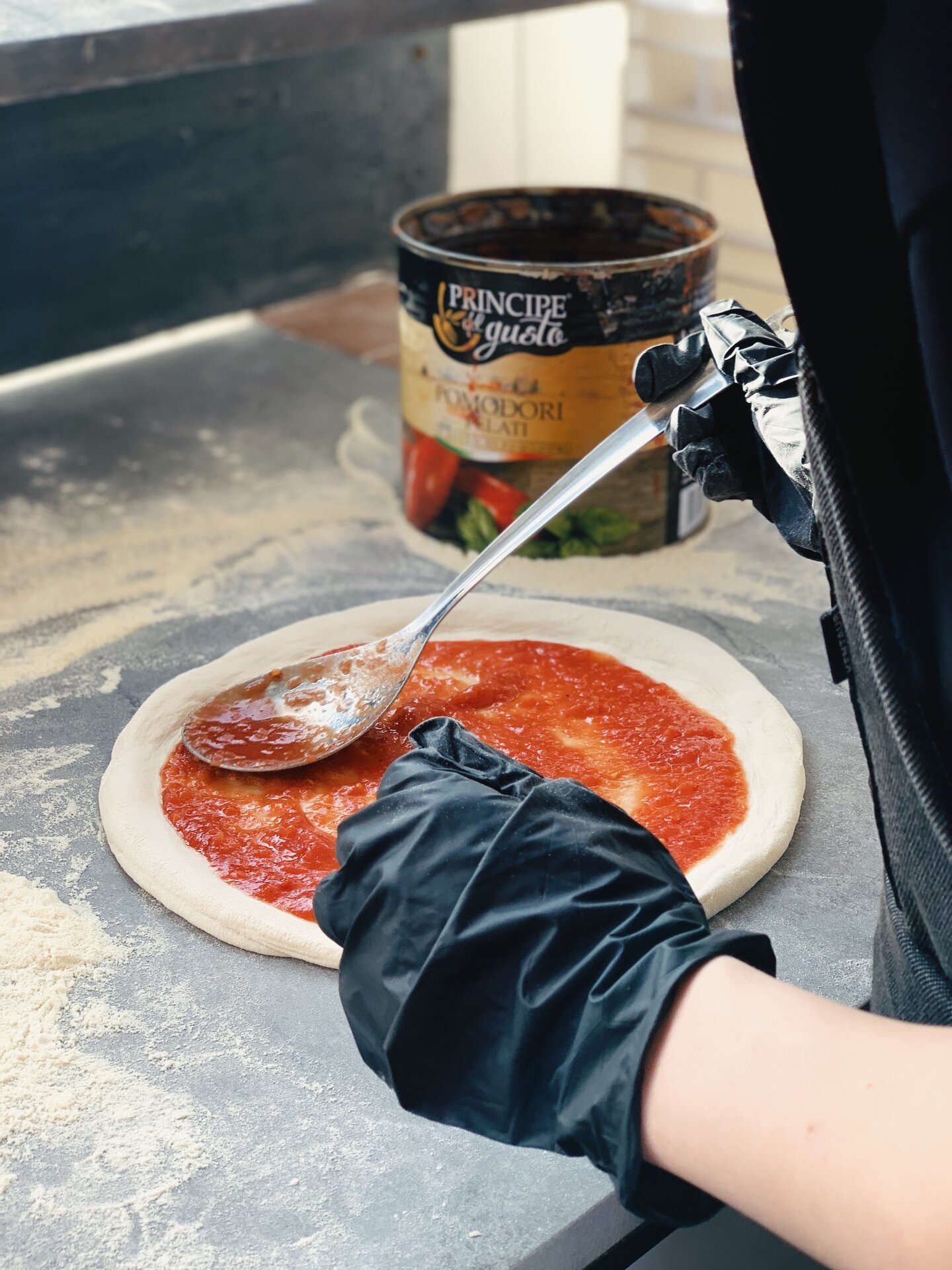 Hütt-kotiravintolan pitsan valmistuksen työpaja – pitsan laittamista uunivalmiiksi