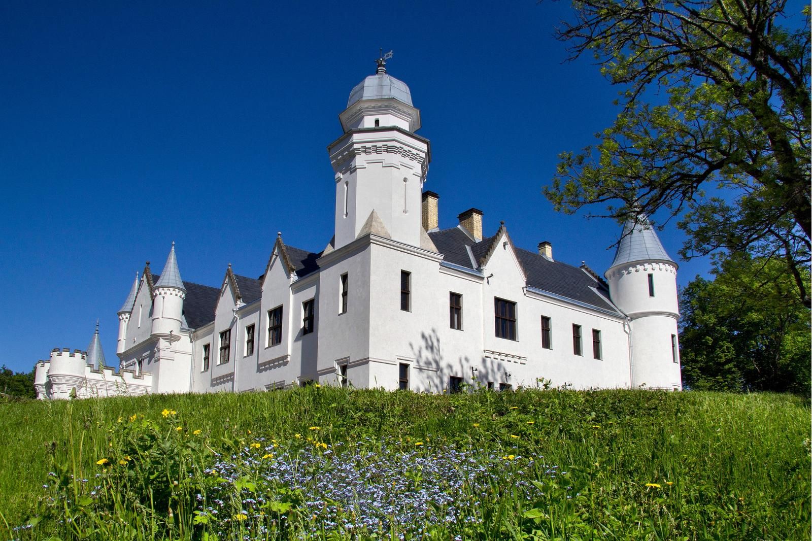 A white fairy-tale castle in the summer greenery of the Onion Route