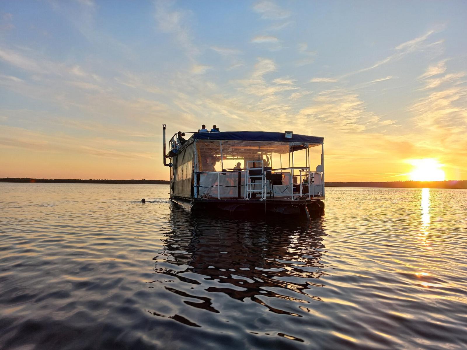 The picture shows the Raft Sauna on Lake Saadjärv, with a sunset in the background