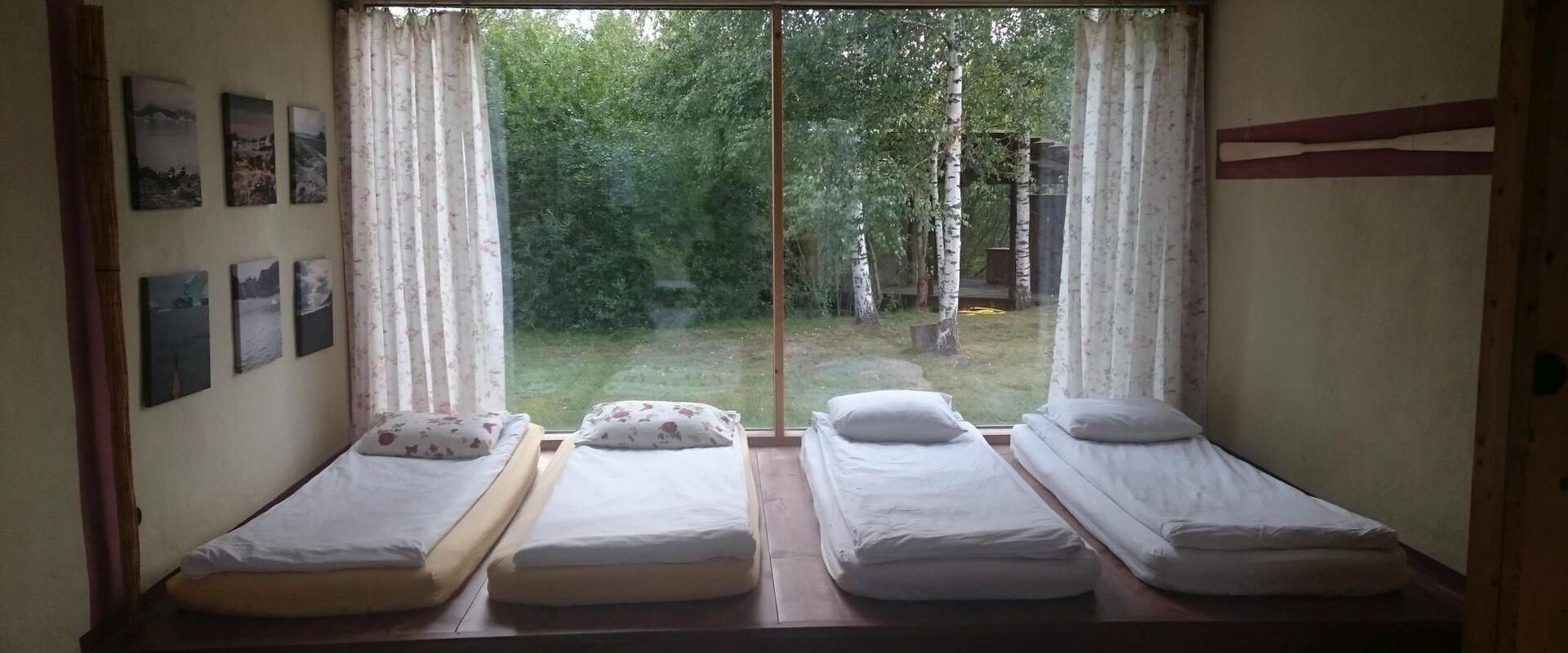 Interior view of a room of the Nina Houses (straw bale houses) with beds and a view of the yard