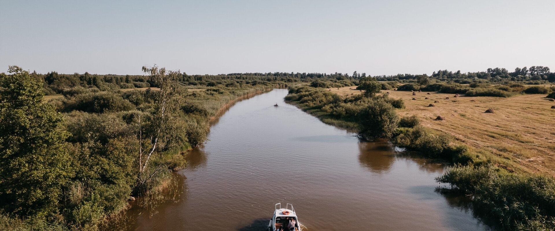 Pildil Kiviranna puhkemaja mootorpaadiga jõel sõitvad inimesed