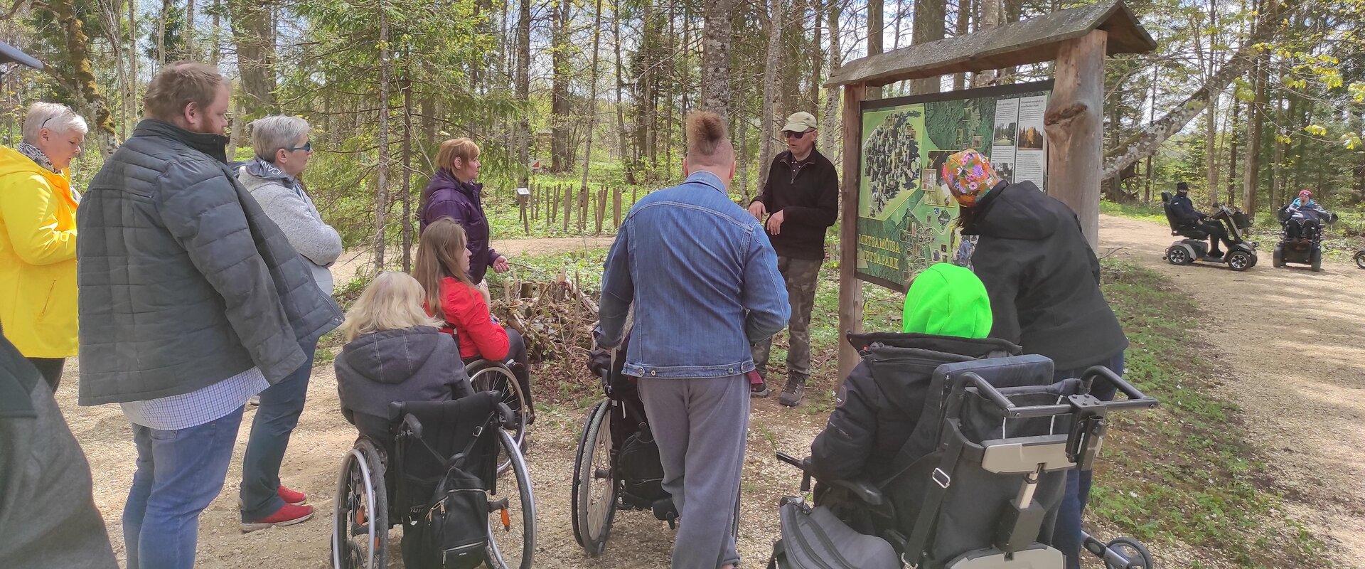 Abivahendiga liikujad loodusmatkal metsapargis oleval ratastoolirajal
