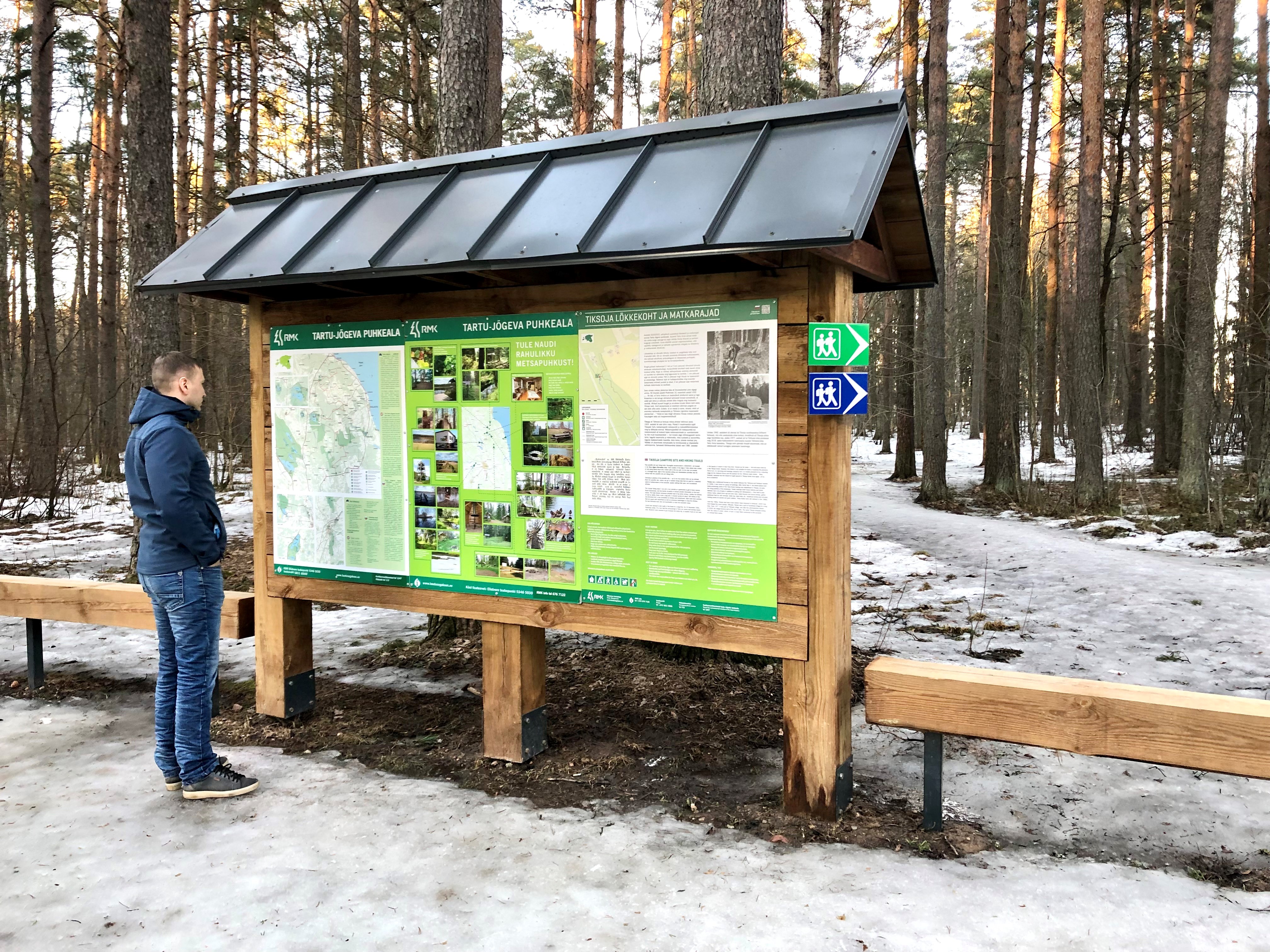 Tiksoja matkarajad ja lõkkekohad mees rajakaardiga tutvumas