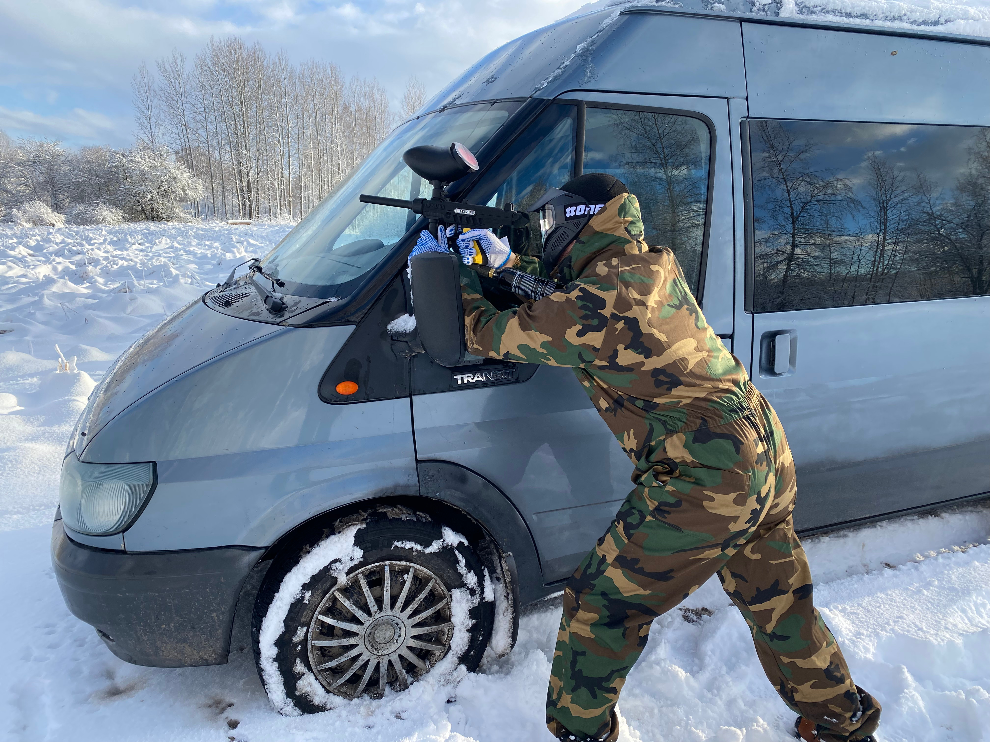 Paintball player in ambush behind car