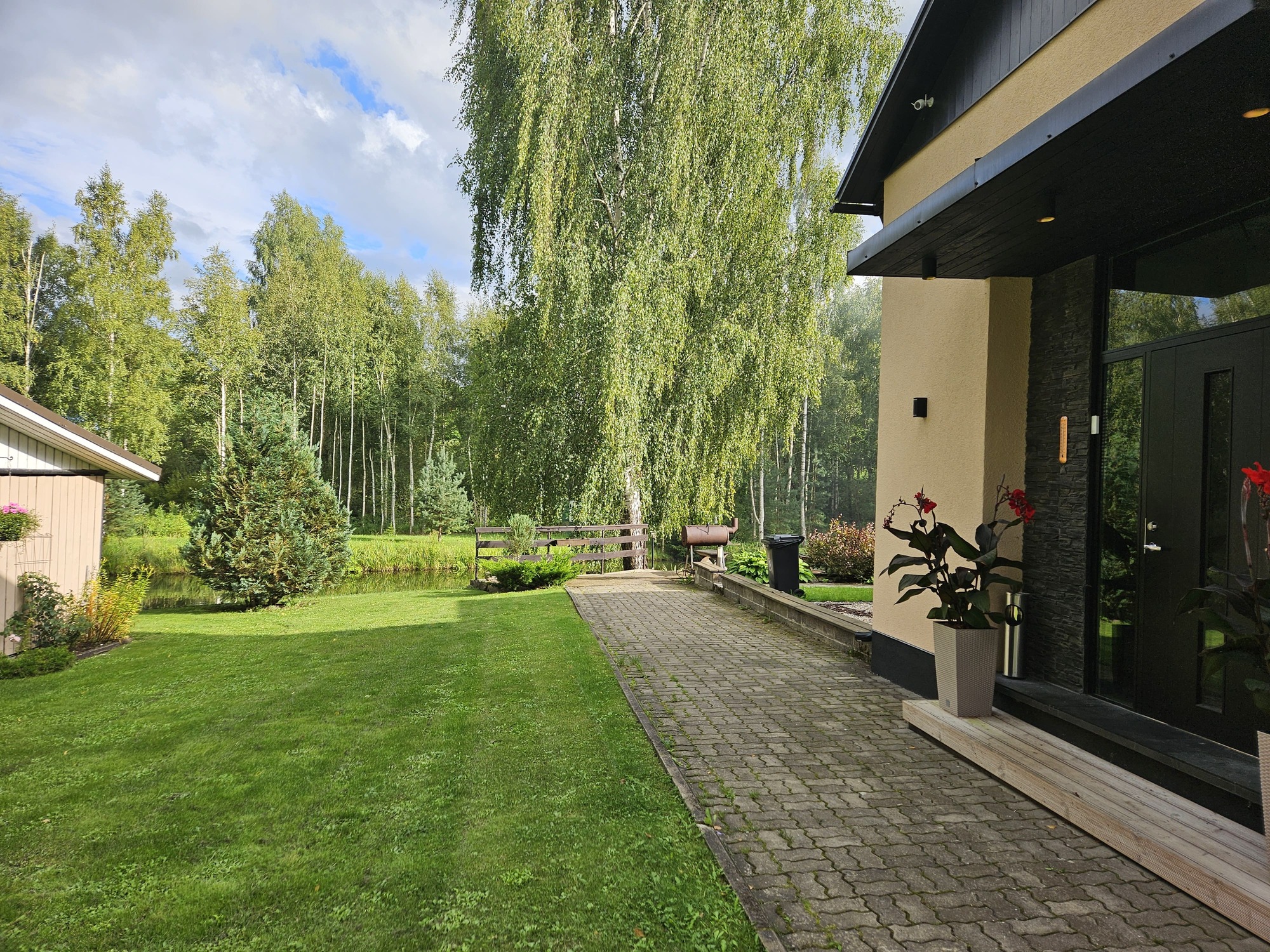 Elva Puhkemaja rohelusse ümbritsetud hoov ja maja.