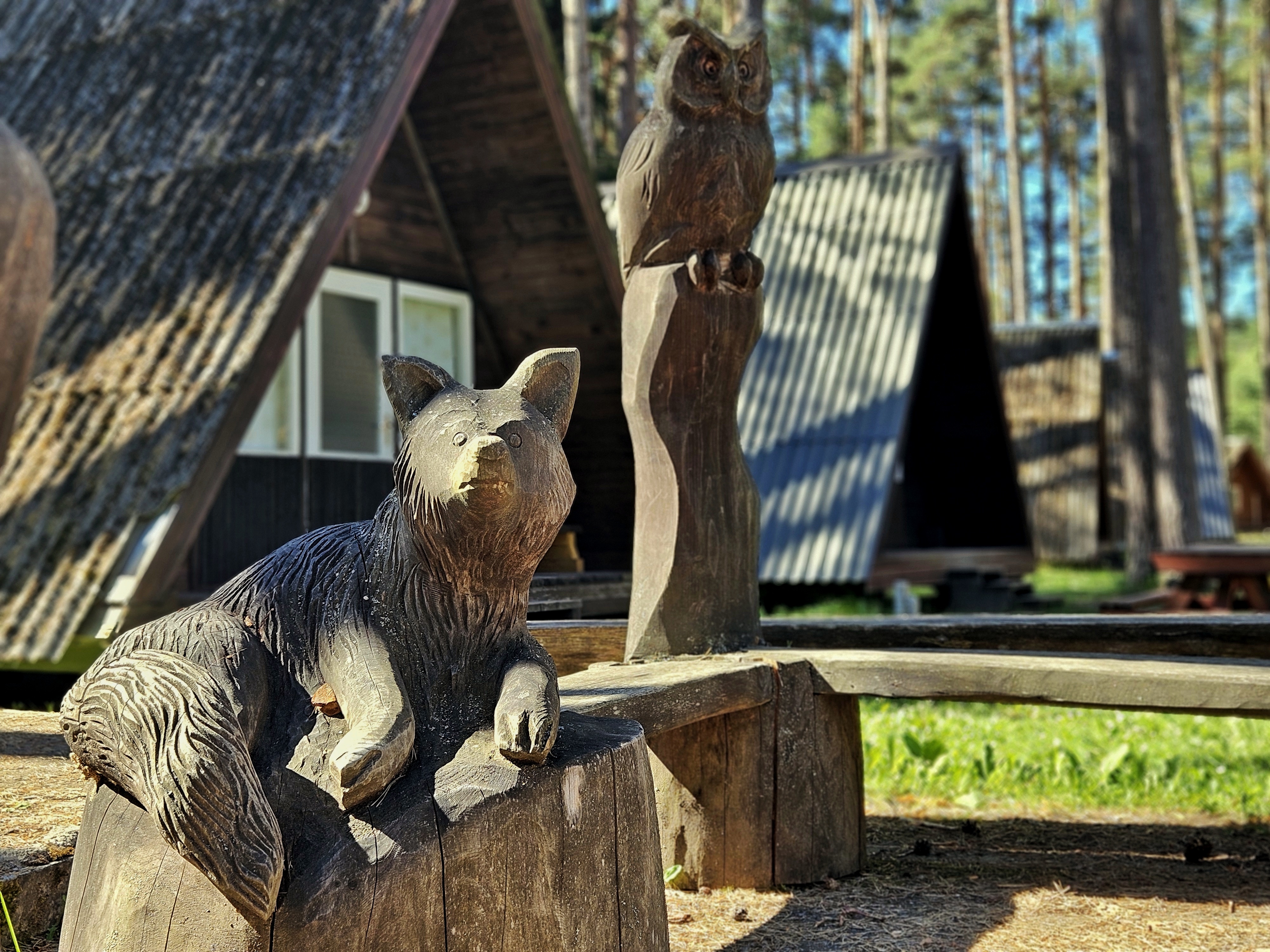 Wooden animal sculptures by camping huts at Tartu