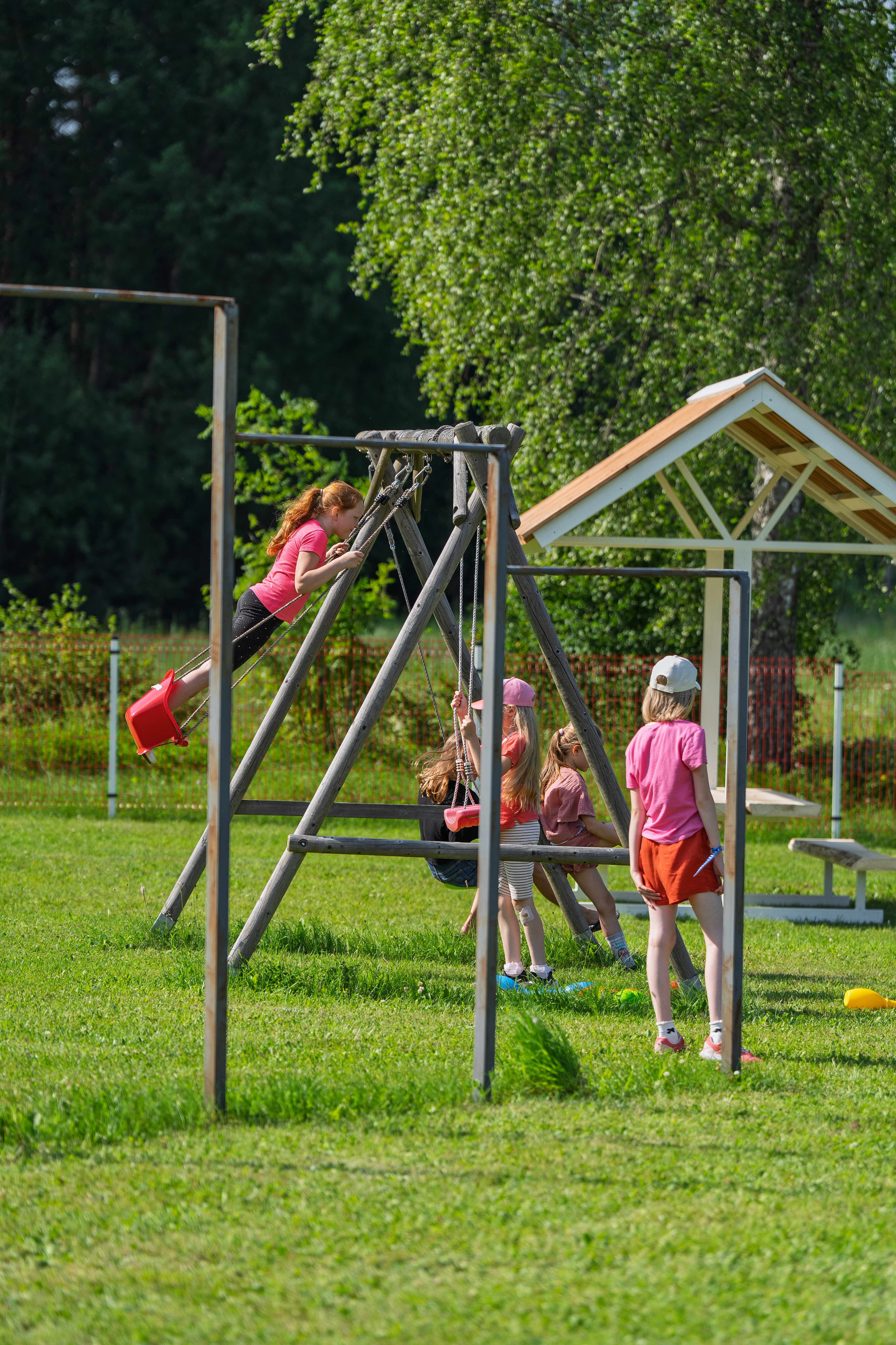 Mänguväljak, kus asuvad turnimispuud, kiiged ja kõrval piknikuplats