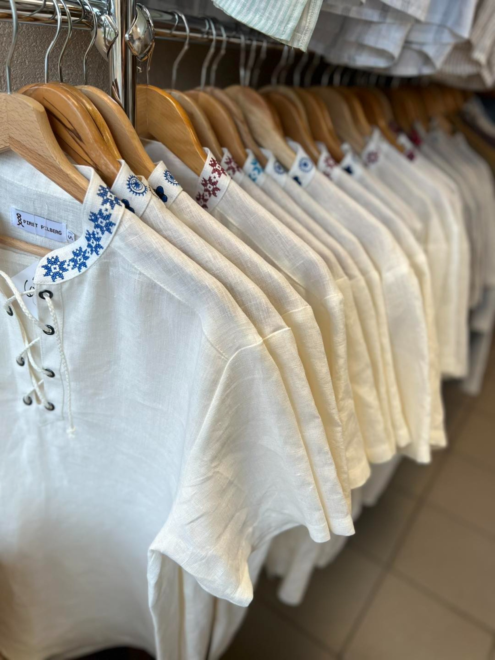 Linased riided kaupluses, valged pluusid rahvusliku motiiviga