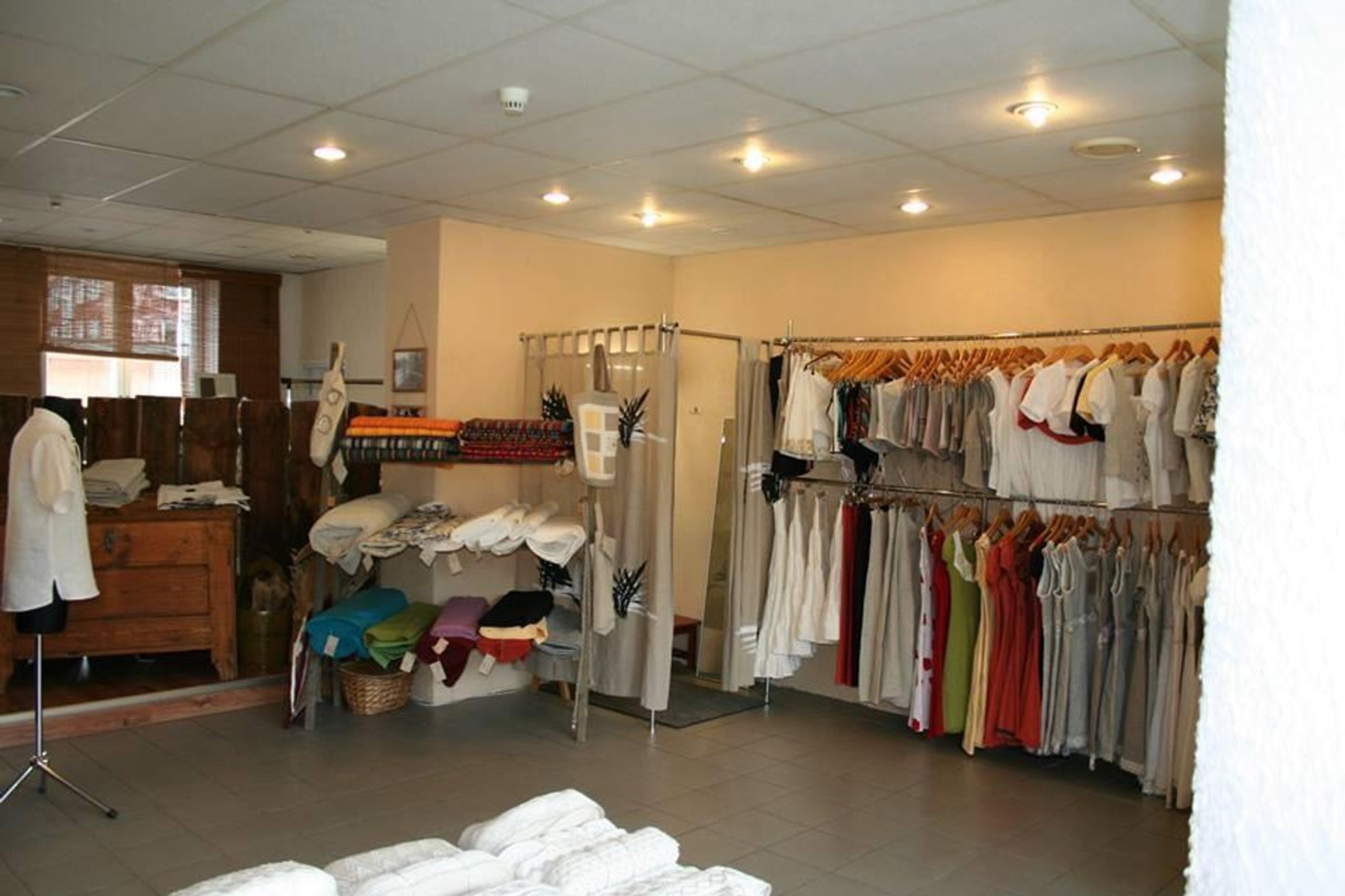 Vaade salongile, kus on väljapanek erinevatest linastest riietest