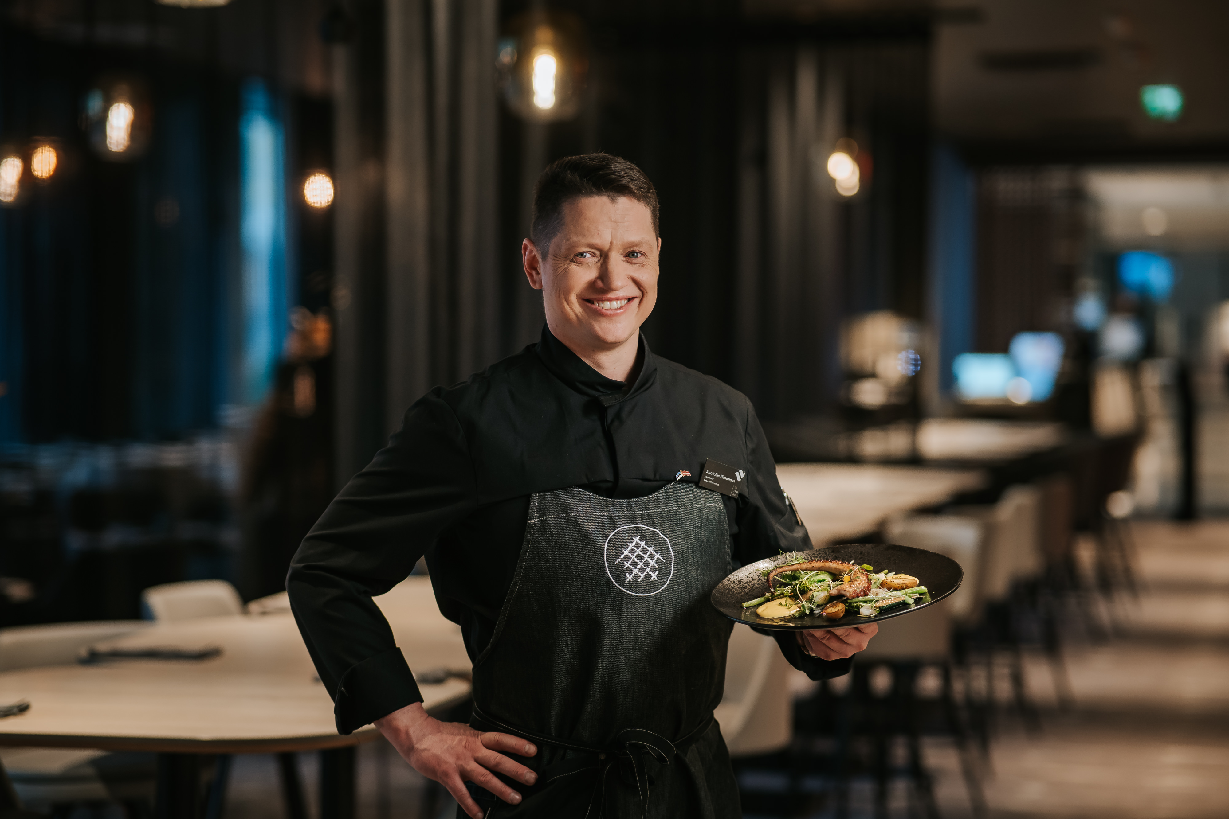 Peakakk Anatolijs Pimanovs taldrikule serveeritud õhtusöögiga, mida ta käes hoiab.