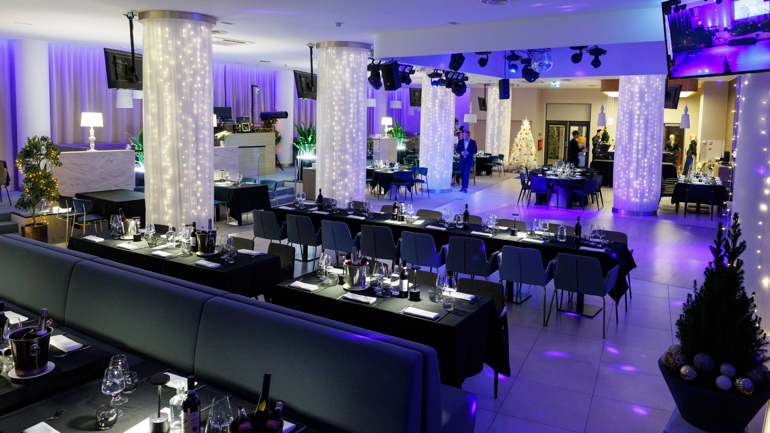Sinise tooniga prožektorid ja valged jõulutuled loovad restoranis piduliku õhkkonna.