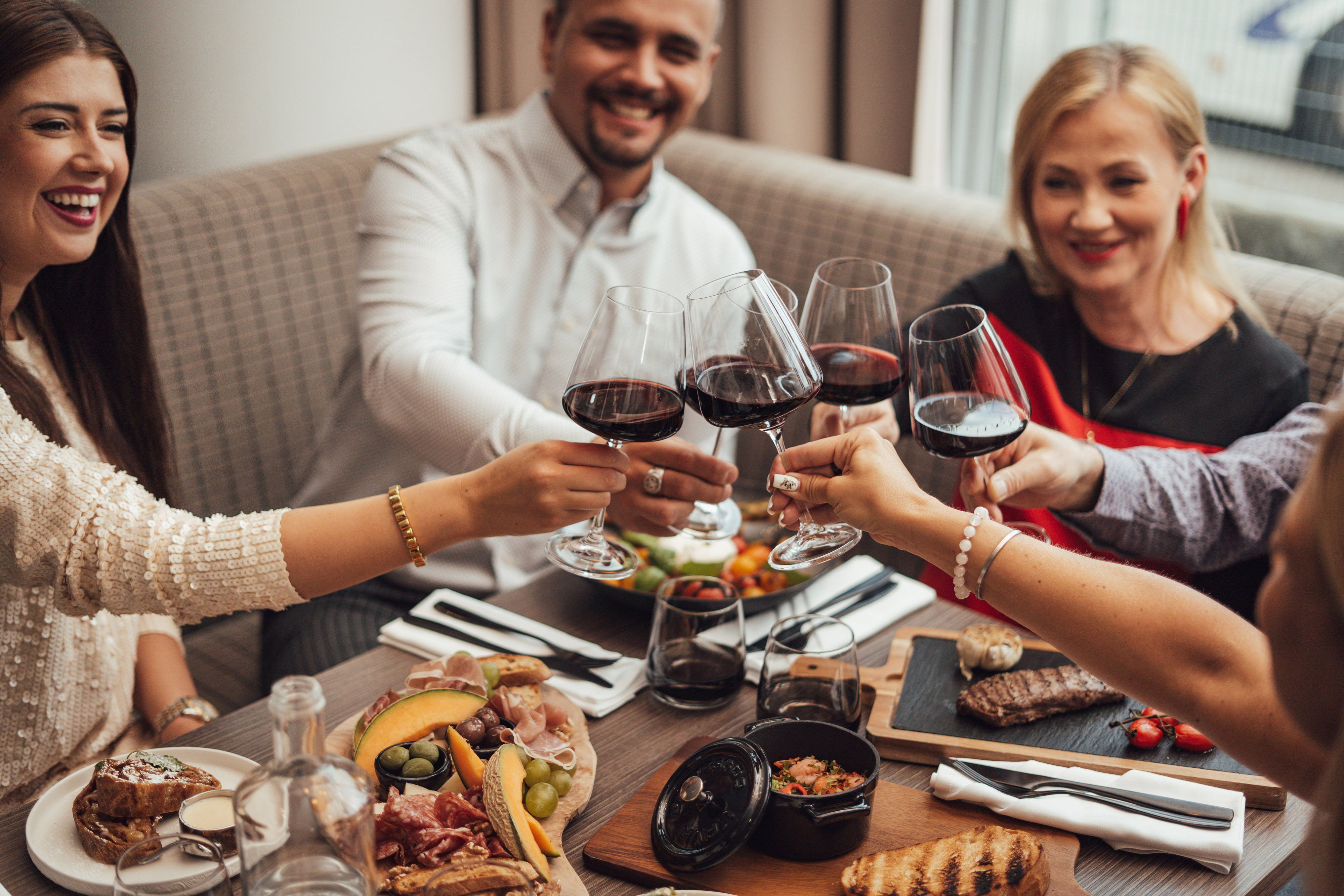 Neli pereliiget lõõvad laua keskel punaveinipokaale kokku. Õhkkond on elegantselt pidulik.