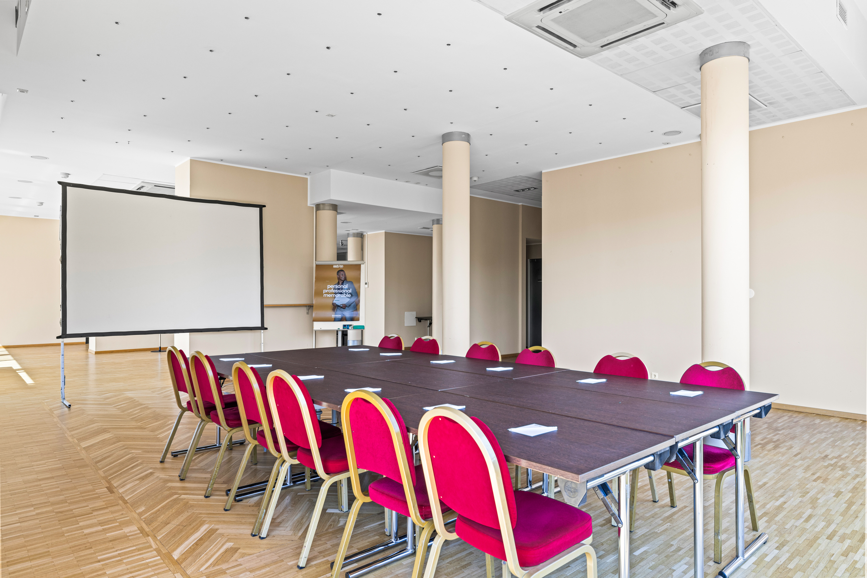 Telpa ar galdiem un ekrānu