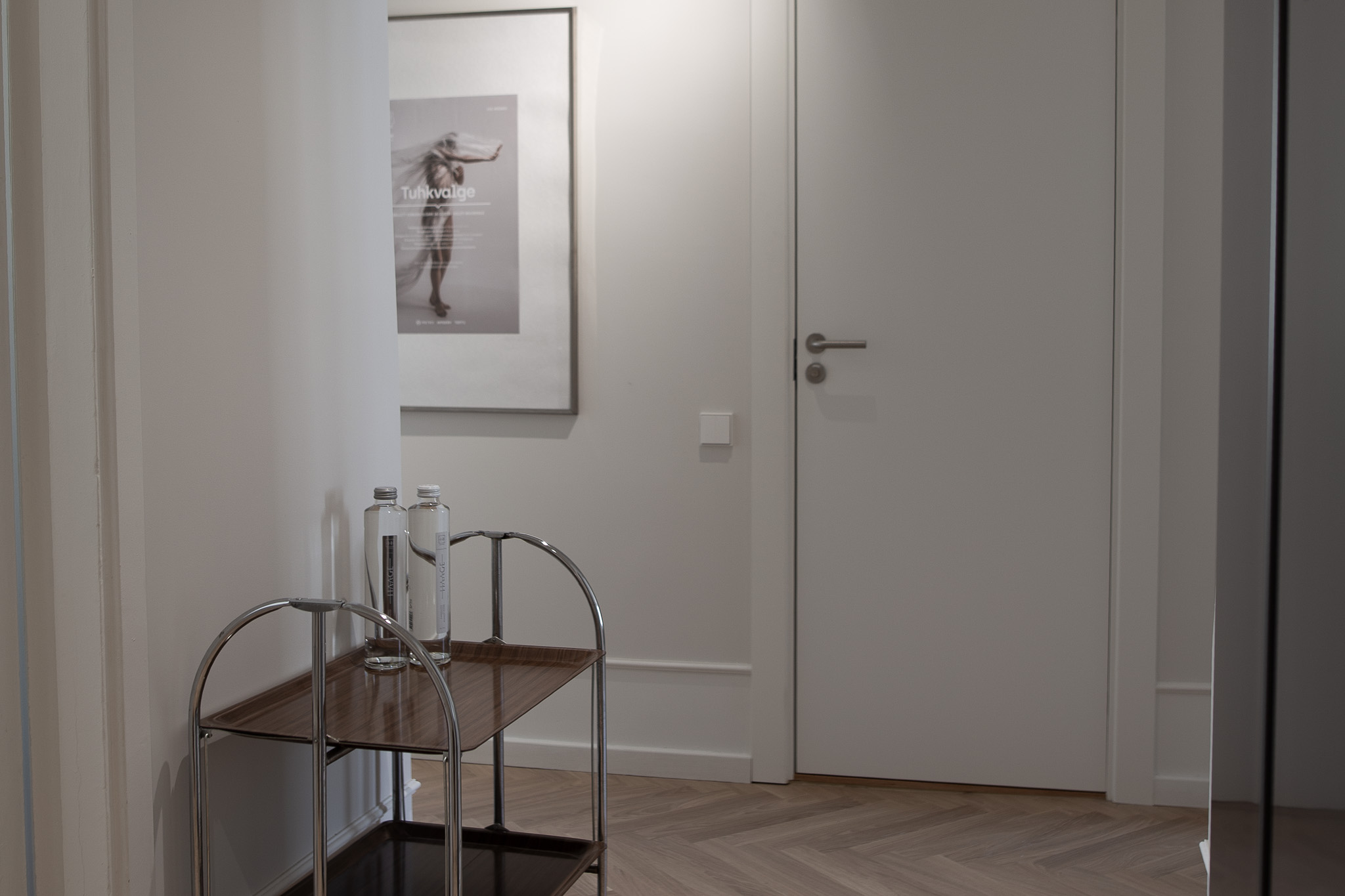 Tartu Rātslaukuma dzīvoklī, ar servēšanas galdu un ūdens pudelēm