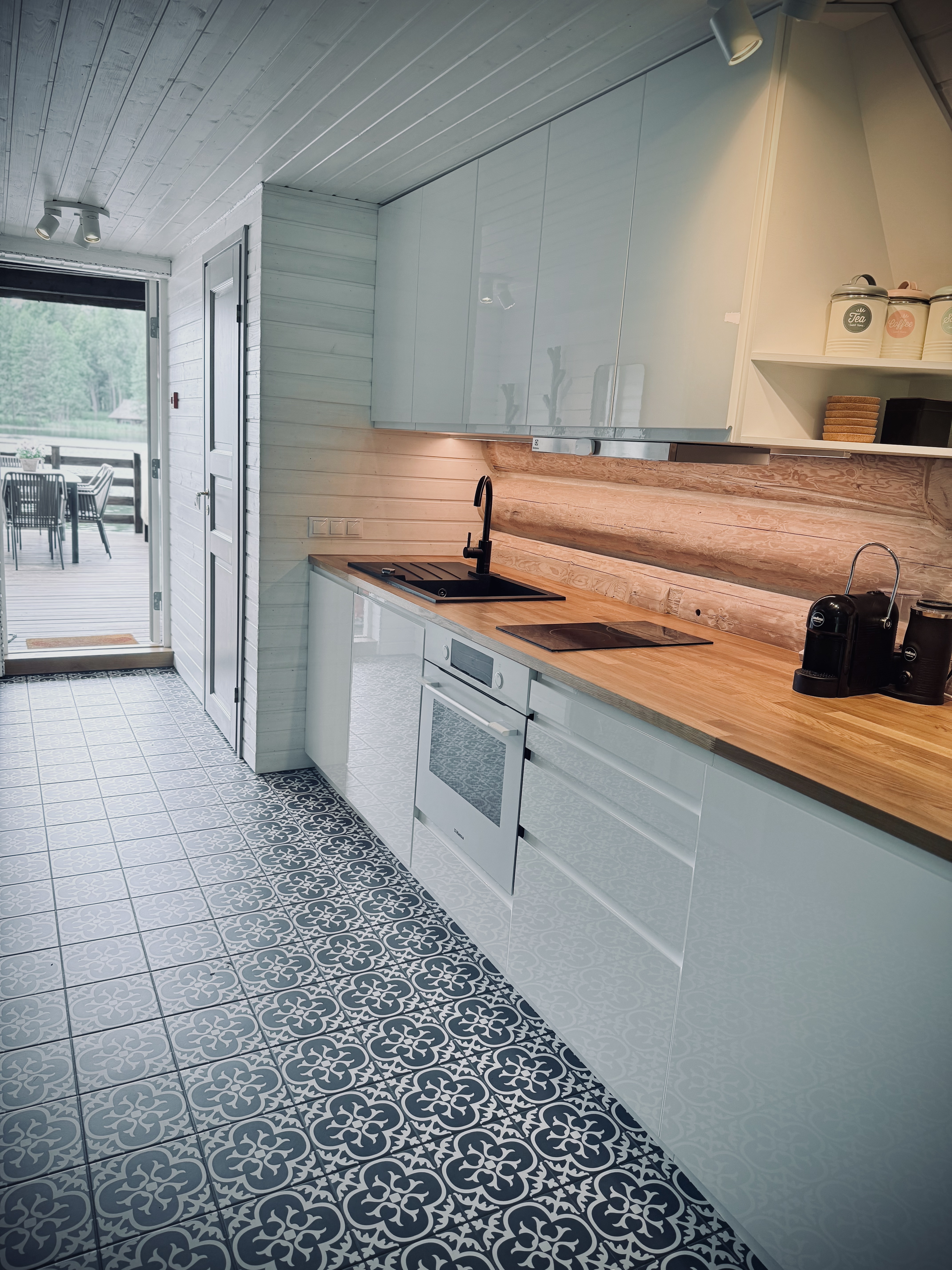 Atpūtas mājas virtuve un skats no virtuves uz terasi