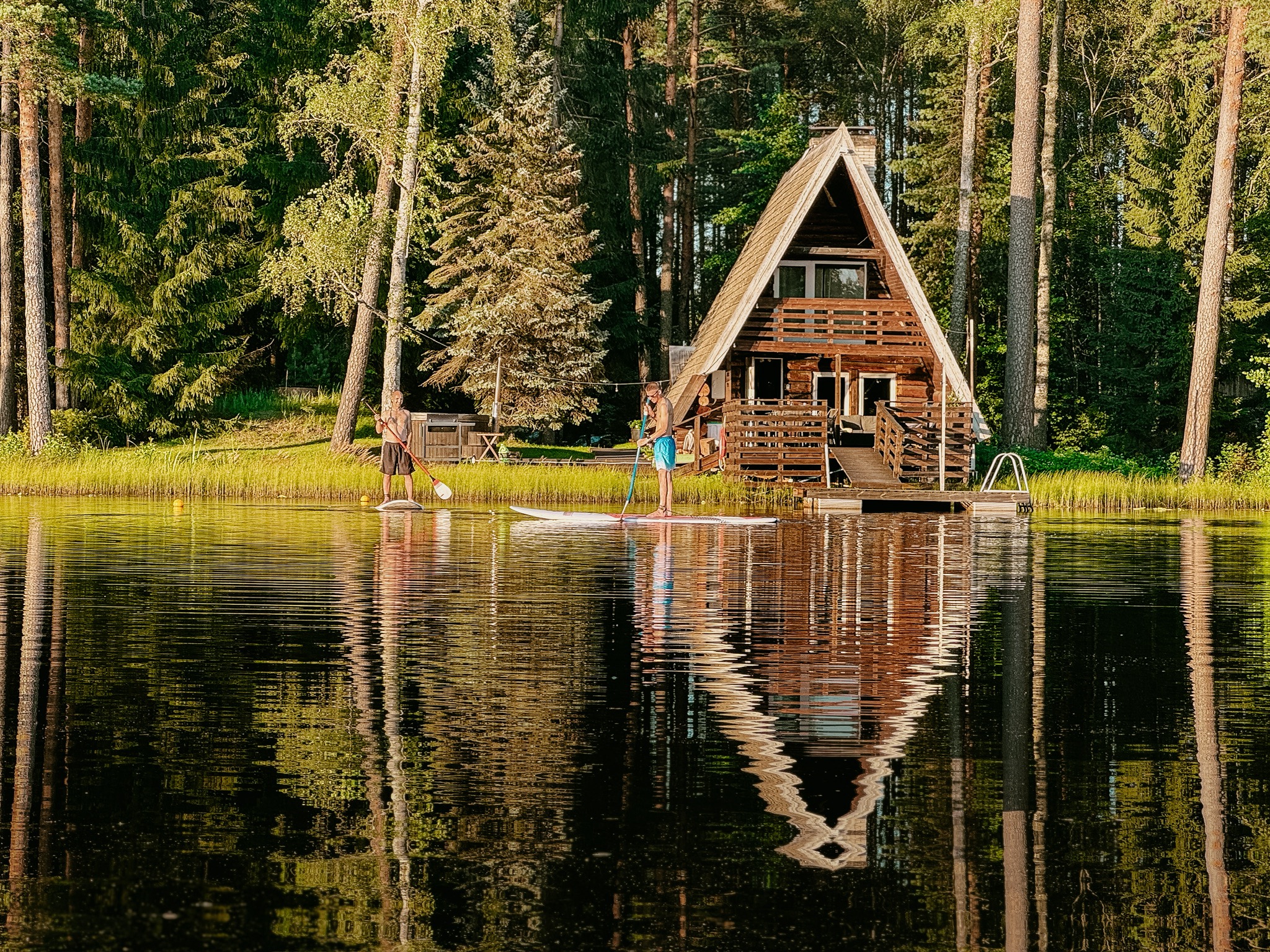 Skats uz ezeru ar mazu atpūtas māju vasarā