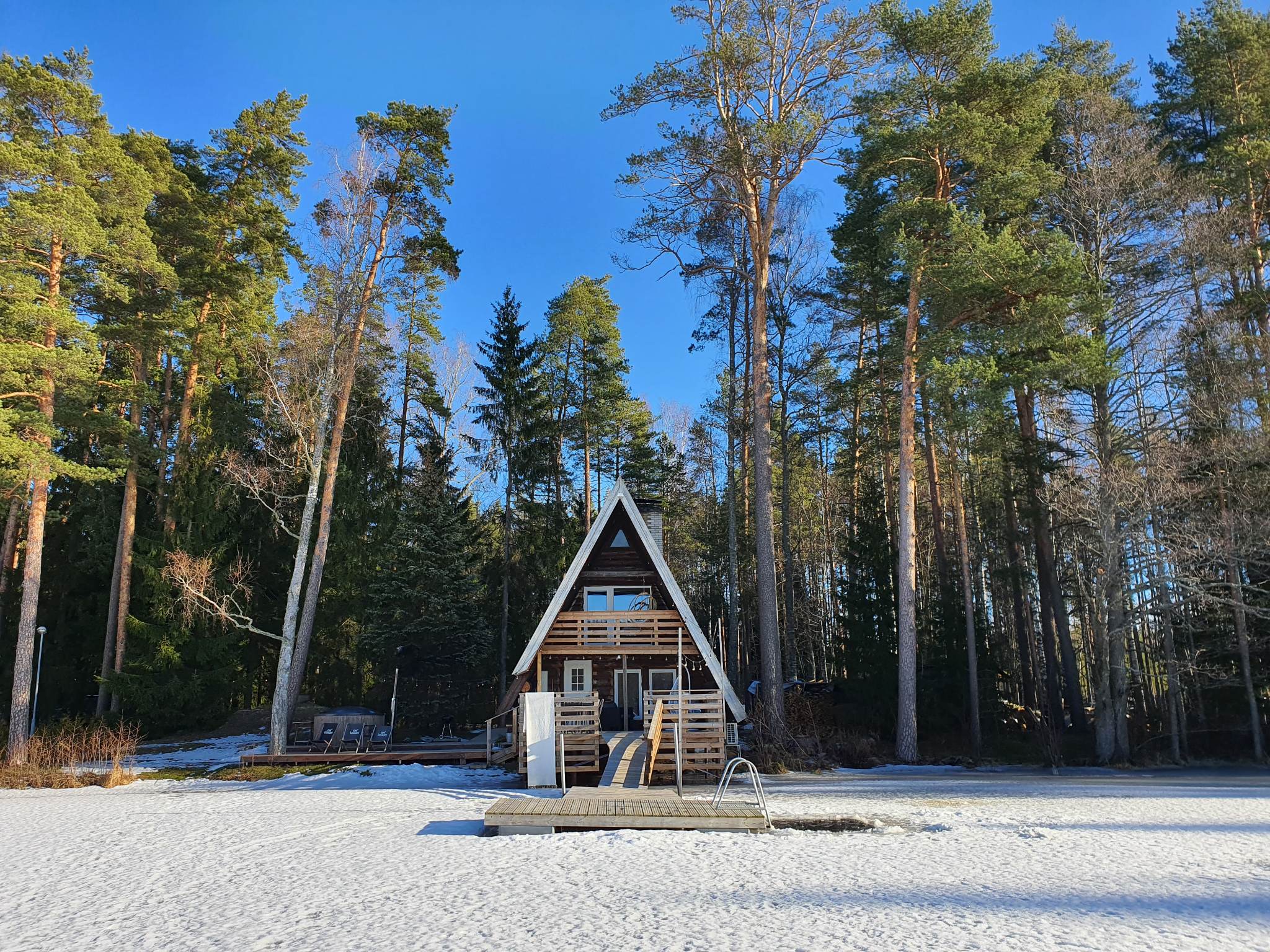 Atpūtas mājas skats no aizsalušā ezera ziemā