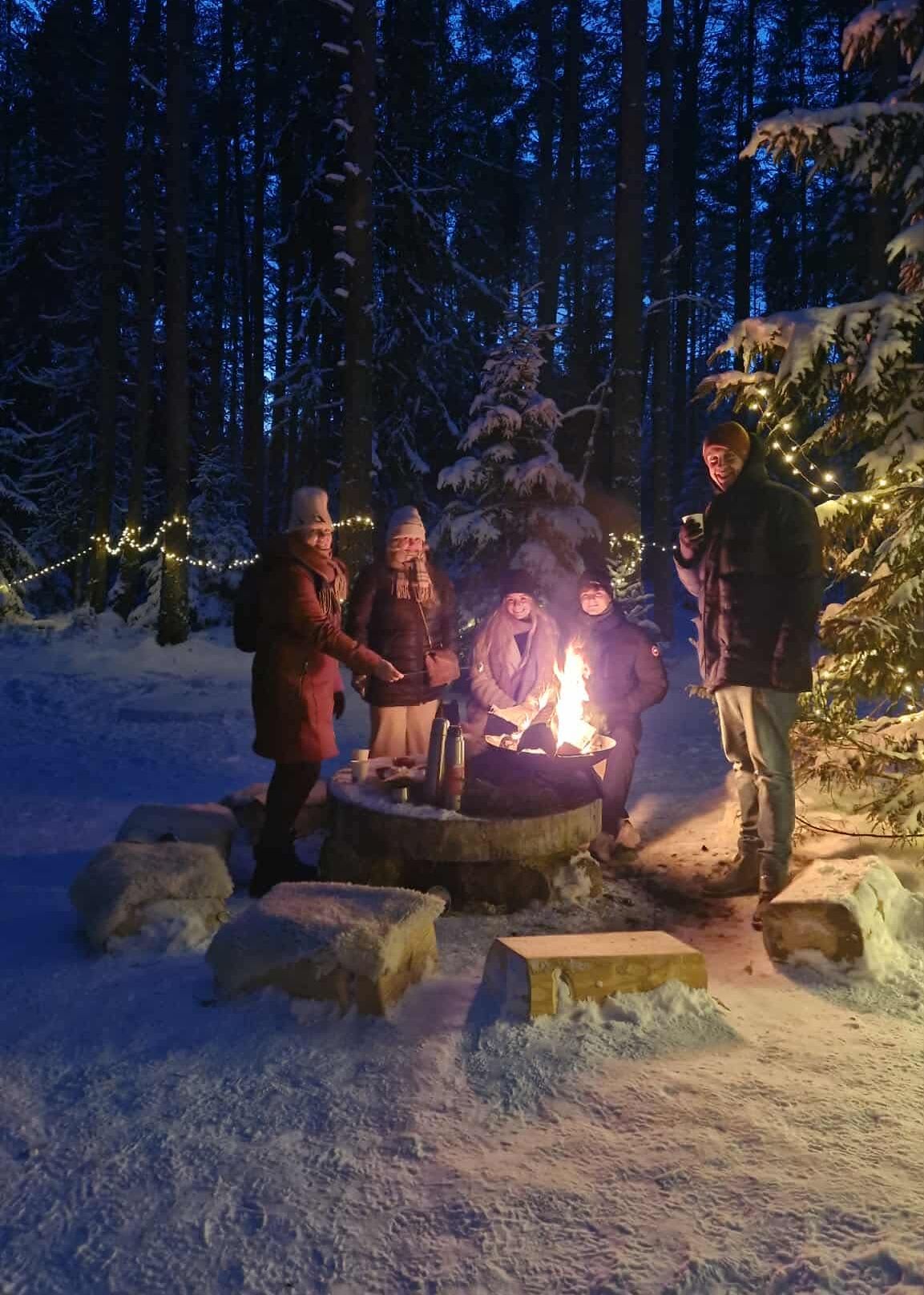 Külalised õhtuse lõkke ümber sooja teed nautimas