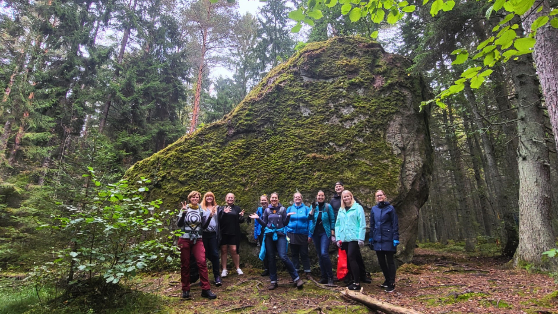 Menschen neben einem großen Findling