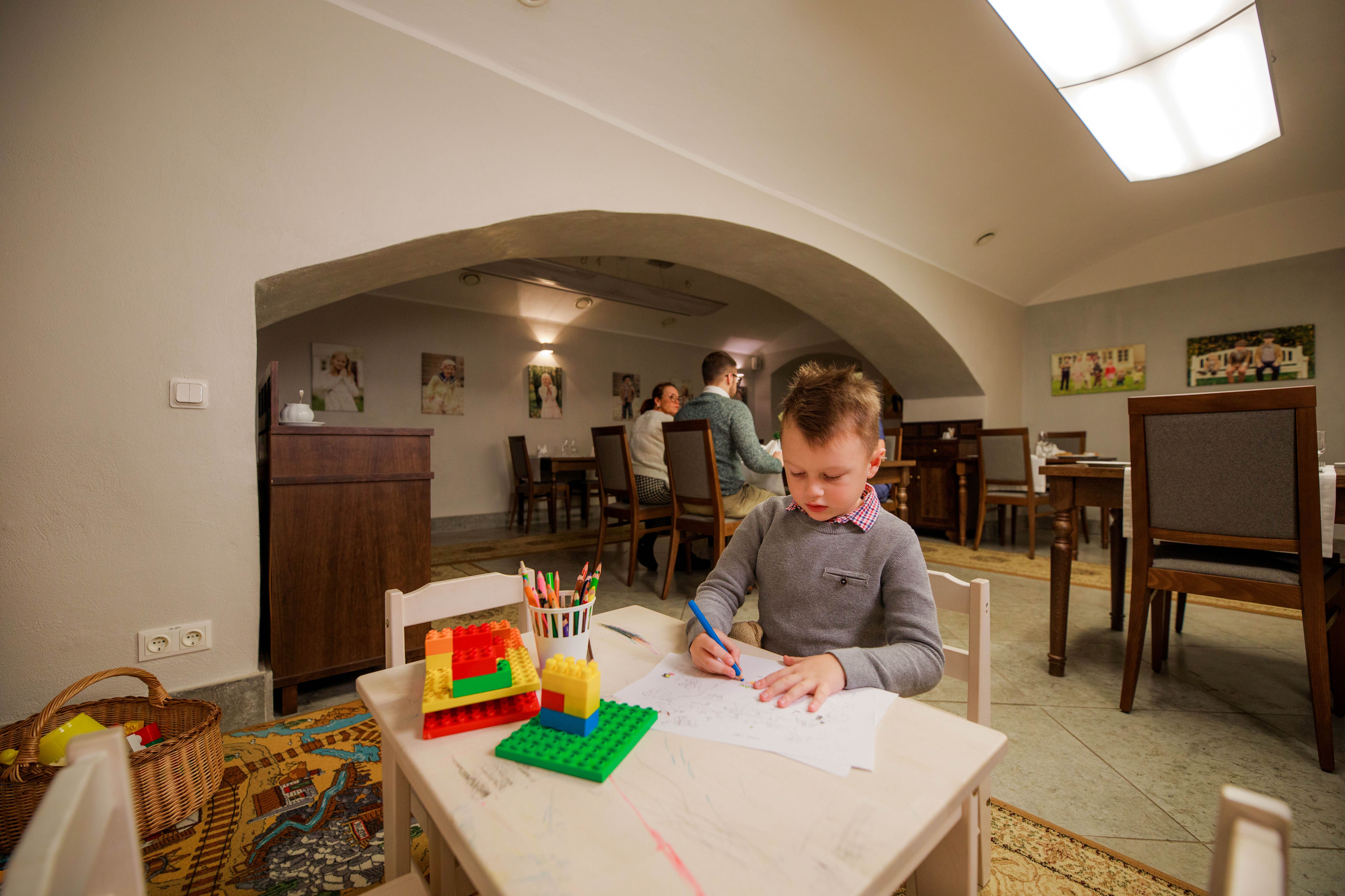 Saka Mõisa restoran Cliffi peresaalis laps istuba ja joonistab