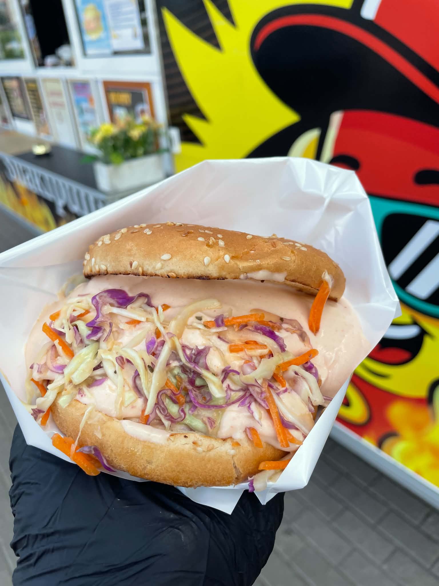 90ndate stiilis kapsa ja porgandi salati ja rohke kastmega burger Snäkipunkti toiduhaagise taustal