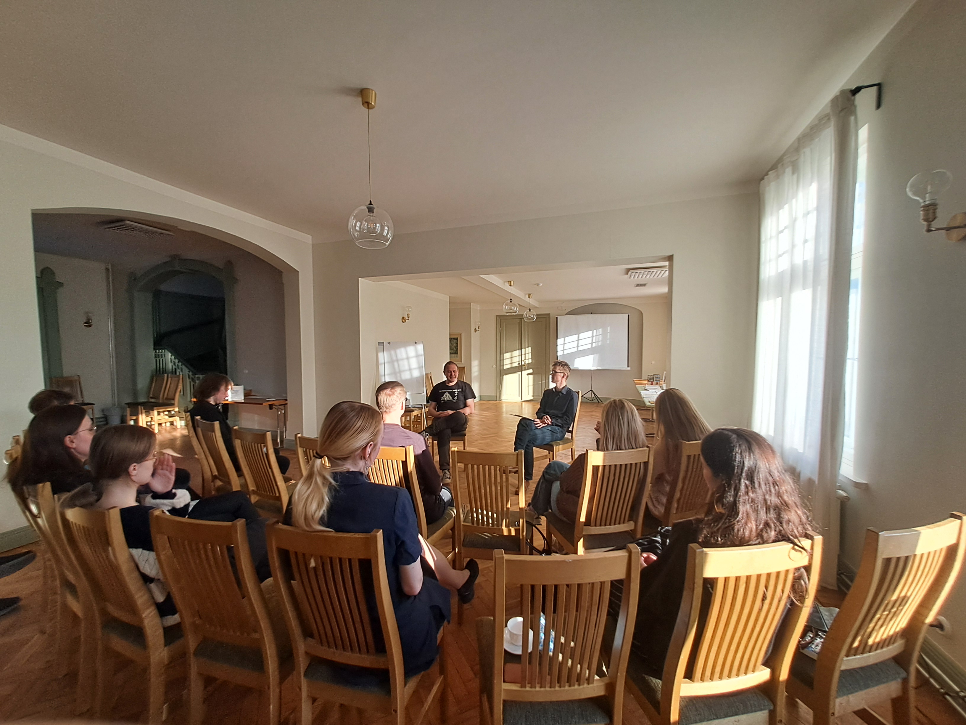 Vestlusringis osalejad istuvad saalis ringjalt paigutatud toolidel